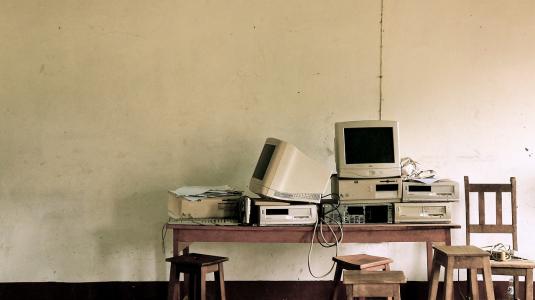 vieux ordinateurs posés sur un vieux bureau