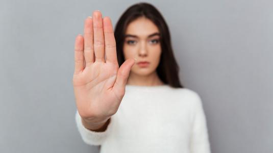 Femme qui stoppe un danger avec sa main